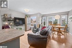 Living room featuring light wood-type flooring and a textured ceiling - 