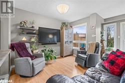 Living room featuring a textured ceiling and light hardwood / wood-style floors - 