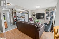 Living room with light wood-type flooring and a textured ceiling - 