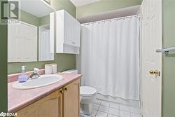 Full bathroom with tile patterned floors, vanity, toilet, and shower / bathtub combination with curtain - 