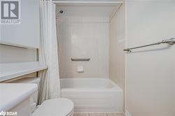 Full bathroom featuring shower / bathtub combination with curtain, tile patterned flooring, vanity, and toilet - 