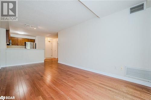 Unfurnished living room with a textured ceiling and light hardwood / wood-style flooring - 2300 Parkhaven Boulevard Unit# 103, Oakville, ON - Indoor