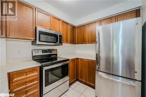 Kitchen featuring light tile patterned floors and appliances with stainless steel finishes - 2300 Parkhaven Boulevard Unit# 103, Oakville, ON - Indoor Photo Showing Kitchen