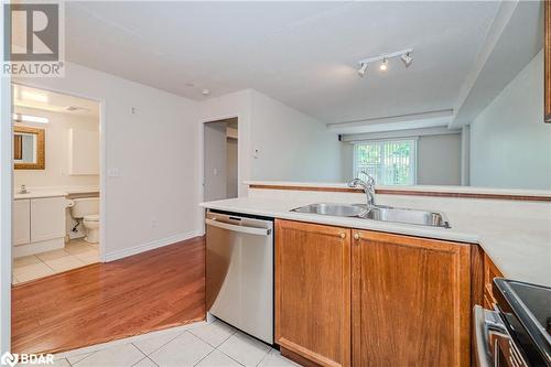 Kitchen with stainless steel dishwasher, light tile patterned floors, sink, and range - 2300 Parkhaven Boulevard Unit# 103, Oakville, ON - Indoor Photo Showing Kitchen With Double Sink