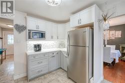 Kitchen with white cabinets, appliances with stainless steel finishes, and tasteful backsplash - 