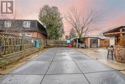 Patio terrace at dusk featuring an outdoor bar and covered inground pool - 