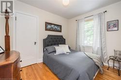 Bedroom with light hardwood / wood-style floors and multiple windows - 