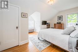 Bedroom featuring light wood-type flooring, multiple windows, and lofted ceiling - 