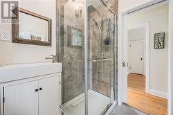 Bathroom featuring tile patterned flooring, vanity, and walk in shower - 