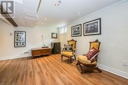 Sitting room with hardwood / wood-style flooring and ornamental molding - 