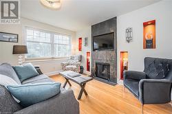 Living room with hardwood / wood-style flooring and a tile fireplace - 