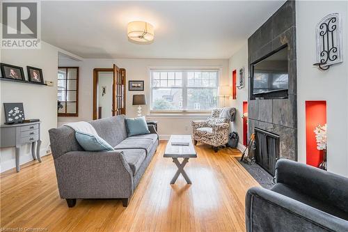 Living room with light hardwood / wood-style floors and a tile fireplace - 48 Dane Street, Kitchener, ON - Indoor Photo Showing Living Room With Fireplace