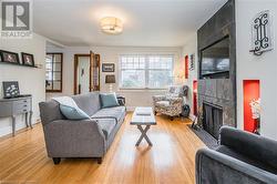 Living room with light hardwood / wood-style floors and a tile fireplace - 