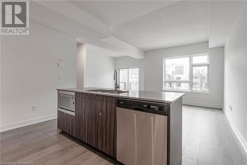 Kitchen featuring plenty of natural light, a center island with sink, sink, appliances with stainless steel finishes, and dark brown cabinets - 1121 Cooke Boulevard Unit# 7, Burlington, ON - Indoor Photo Showing Kitchen With Double Sink