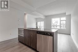 Kitchen featuring plenty of natural light, a center island with sink, sink, appliances with stainless steel finishes, and dark brown cabinets - 