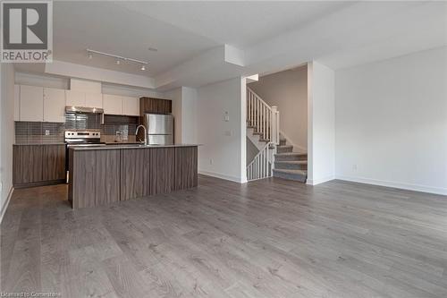 Kitchen featuring stainless steel appliances, a kitchen island with sink, sink, light hardwood / wood-style flooring, and white cabinetry - 1121 Cooke Boulevard Unit# 7, Burlington, ON - Indoor Photo Showing Kitchen