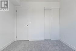 Unfurnished bedroom with carpet floors, elevator, and a closet - 