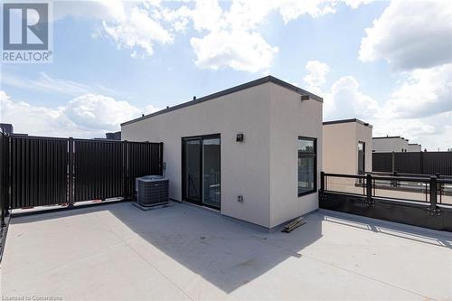 Rear view of house featuring central AC and a patio area - 1121 Cooke Boulevard Unit# 7, Burlington, ON - Outdoor With Exterior