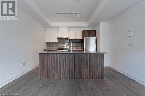 Kitchen featuring appliances with stainless steel finishes, tasteful backsplash, sink, a center island with sink, and white cabinets - 1121 Cooke Boulevard Unit# 7, Burlington, ON - Indoor Photo Showing Kitchen