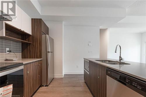 Kitchen featuring ventilation hood, stainless steel appliances, sink, light hardwood / wood-style floors, and white cabinetry - 1121 Cooke Boulevard Unit# 7, Burlington, ON - Indoor Photo Showing Kitchen With Double Sink