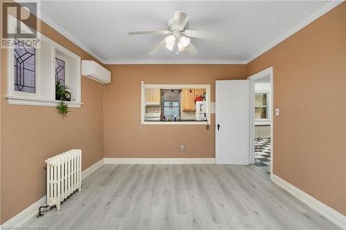 Unfurnished room featuring an AC wall unit, crown molding, ceiling fan, light wood-type flooring, and radiator heating unit - 349 Kipling Avenue, Etobicoke, ON - Indoor Photo Showing Other Room