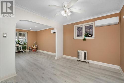 Unfurnished room with a wall mounted AC, radiator heating unit, ornamental molding, and light wood-type flooring - 349 Kipling Avenue, Etobicoke, ON - Indoor Photo Showing Other Room