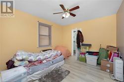 Bedroom with ceiling fan and light hardwood / wood-style floors - 