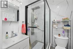 Bathroom featuring decorative backsplash, walk in shower, vanity, tile walls, and toilet - 