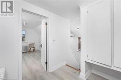 Hallway with radiator heating unit, light wood-type flooring, an AC wall unit, and lofted ceiling - 