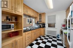 Kitchen with radiator heating unit, electric range, and sink - 