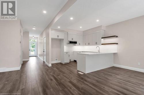 Kitchen featuring dark hardwood / wood-style floors, sink, white cabinetry, and kitchen peninsula - 3C Balsam Street, Innerkip, ON - Indoor Photo Showing Kitchen