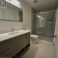 Bathroom featuring tile patterned floors, walk in shower, vanity, and toilet - 