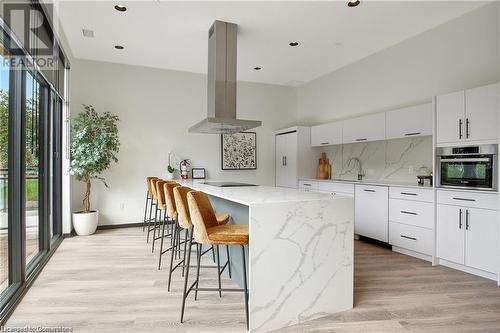 Kitchen with backsplash, island range hood, a kitchen island, white cabinetry, and oven - 525 New Dundee Road Unit# 602, Kitchener, ON - Indoor Photo Showing Kitchen