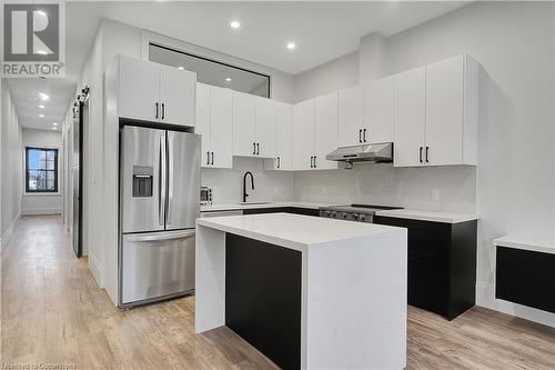 Kitchen featuring a center island, range, sink, stainless steel refrigerator with ice dispenser, and white cabinetry - 29 Main Street Unit# 201, Cambridge, ON - Indoor Photo Showing Kitchen With Upgraded Kitchen