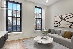 Living room with light hardwood / wood-style floors and a healthy amount of sunlight - 