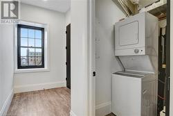 Laundry room featuring stacked washer and clothes dryer and light wood-type flooring - 