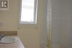 Bathroom with shower / bath combo with shower curtain and sink - 