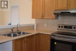 Kitchen featuring sink, tasteful backsplash, and electric stove - 