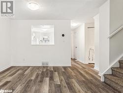 Empty room with a textured ceiling, dark wood-type flooring, and sink - 