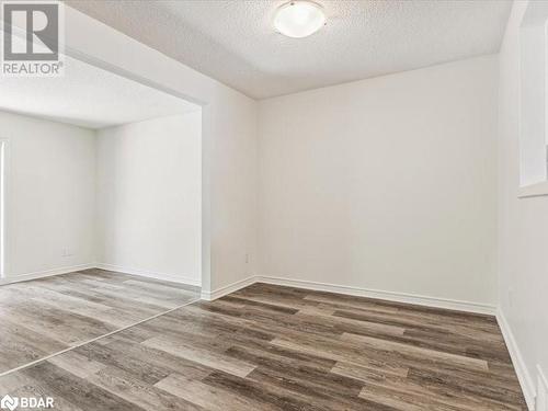 Unfurnished room with dark wood-type flooring and a textured ceiling - 242 Lakeport Road Unit# 22, St. Catharines, ON - Indoor Photo Showing Other Room