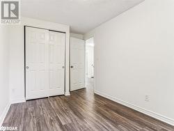 Unfurnished bedroom with dark hardwood / wood-style flooring, a textured ceiling, and a closet - 