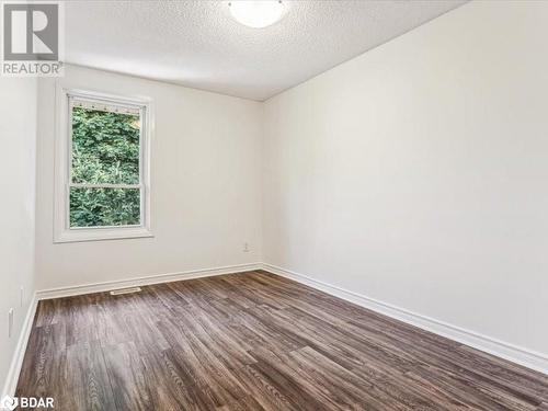 Spare room with a textured ceiling and dark hardwood / wood-style floors - 242 Lakeport Road Unit# 22, St. Catharines, ON - Indoor Photo Showing Other Room