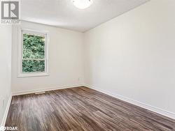 Spare room with a textured ceiling and dark hardwood / wood-style floors - 