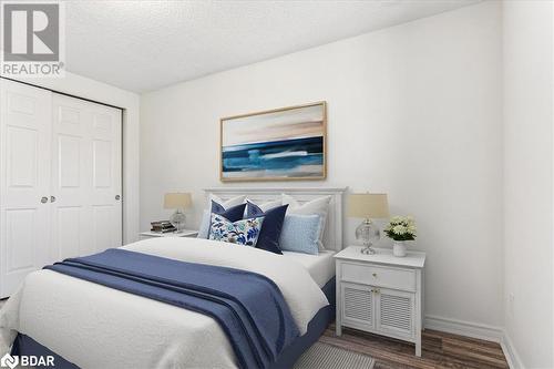 Bedroom featuring a textured ceiling, hardwood / wood-style flooring, and a closet - 242 Lakeport Road Unit# 22, St. Catharines, ON - Indoor Photo Showing Bedroom