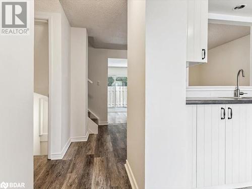 Hall with a textured ceiling, dark hardwood / wood-style floors, and sink - 242 Lakeport Road Unit# 22, St. Catharines, ON - Indoor Photo Showing Other Room