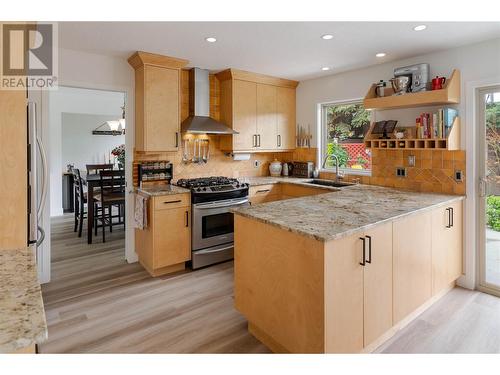 Updated kitchen overlooking the private backyard and open to a breakfast nook and family room below - 600 Welke Road, Kelowna, BC - Indoor Photo Showing Kitchen