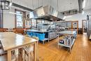 Kitchen featuring stainless steel fridge, wood walls, light hardwood / wood-style floors, a kitchen island, and exhaust hood - 5183 Trussler Road, Ayr, ON 