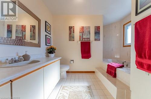 Bathroom with a relaxing tiled tub, tile patterned flooring, toilet, and vanity - 2080 Sixth Line, Oakville, ON - Indoor Photo Showing Bathroom