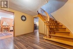 Stairs with hardwood / wood-style floors and a textured ceiling - 