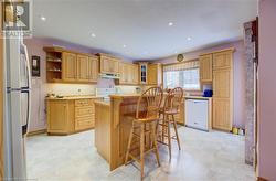 Kitchen with white appliances, a kitchen island, and a breakfast bar area - 